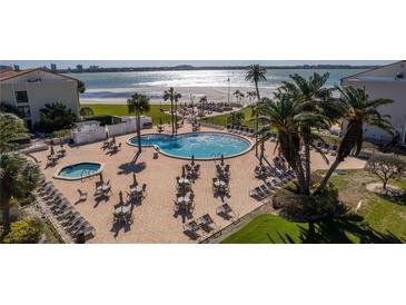 Resort-style pool and patio with lounge seating, dining tables, and views of the Gulf of Mexico at 830 S Gulfview Blvd # 501, Clearwater Beach, FL 33767