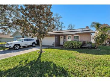 Charming single-story home features a well-manicured lawn, landscaping, and a private driveway at 908 Evelyn Ave, Clearwater, FL 33764