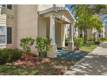 Up-close exterior of the entrance with decorative columns, mature landscaping, and a well-maintained walkway at 18445 Bridle Club Dr, Tampa, FL 33647