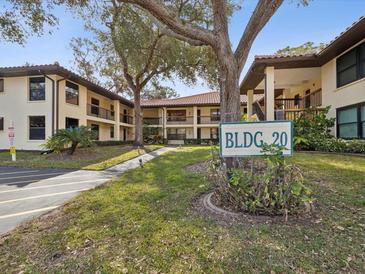 Condominium exterior showcasing well-maintained grounds and building 20 sign with mature landscaping at 2009 Hammock Pine Blvd # 2009, Clearwater, FL 33761