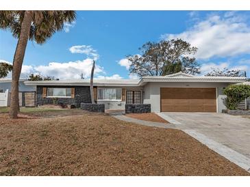 Charming single-story home featuring unique stone accents, a two-car garage and a well-manicured front yard at 2080 Attache Ct, Clearwater, FL 33764