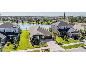Charming home features a well-manicured lawn, mature trees, and water views at 33899 Astoria Cir, Wesley Chapel, FL 33545