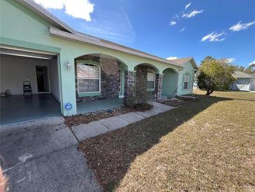 Charming home featuring stone accents, arched entryways, attached garage, and well-maintained landscaping at 6283 Lorraine Ln, Spring Hill, FL 34608