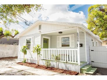 Charming one-story home featuring a cozy front porch, updated siding, and fresh landscaping at 6906 N Central Ave, Tampa, FL 33604