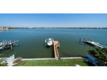 Breathtaking waterfront view of the Gulf Coast from a lush backyard with docks and boat lift at 6976 S Shore S Dr, St Petersburg, FL 33707