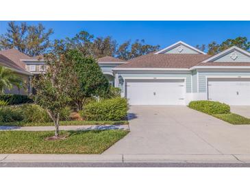 Charming home showcasing a manicured lawn, mature trees, and an attached two-car garage, reflecting a peaceful suburban setting at 13574 Circa Crossing Dr, Lithia, FL 33547