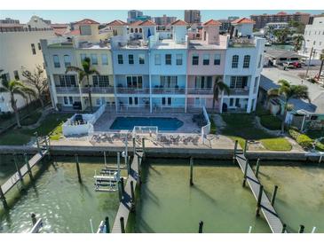 Multi-colored townhouses with a communal pool and docks on the water, offering waterfront living at 140 Brightwater Dr # 1, Clearwater Beach, FL 33767