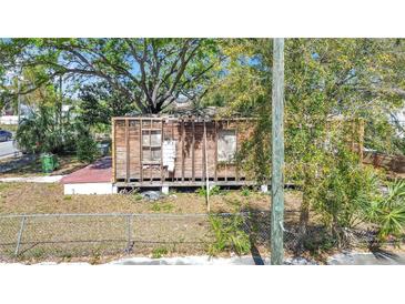 Stripped home features wood frame, no roof, with a small yard at 3601 N 18Th St, Tampa, FL 33605