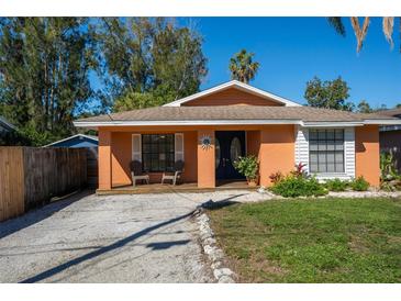 Charming single-story home with a gravel driveway, small front porch, and neat landscaping at 4156 Iola Dr, Sarasota, FL 34231