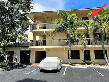 Multi-story condo building featuring balconies, mature trees, and reserved parking spaces at 425 30Th W Ave # C308, Bradenton, FL 34205