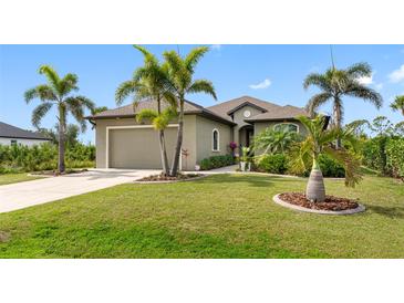 Charming single-story home with manicured lawn, lush landscaping, and a two-car garage at 135 Cabana Way, Rotonda West, FL 33947