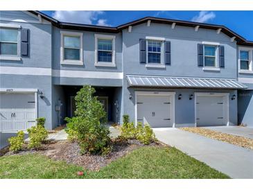 Charming townhome with a two-car garage, shutters, lovely landscaping, and a covered entry at 14477 Editors Note St, Ruskin, FL 33573