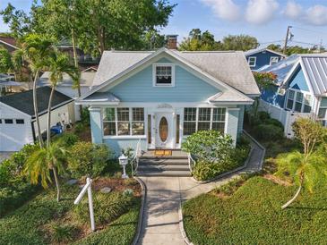 Charming light blue home featuring a landscaped front yard, sidewalk and a white picket mailbox at 210 15Th N Ave, St Petersburg, FL 33704