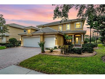 Charming two-story home with a well-manicured lawn, 3-car garage, and inviting entrance, all beneath a picturesque evening sky at 2665 Lakebreeze N Ln, Clearwater, FL 33759