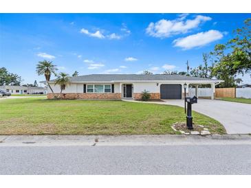 Charming single-story home with a well-manicured lawn and a classic brick accent wall at 269 Algiers Dr, Venice, FL 34293