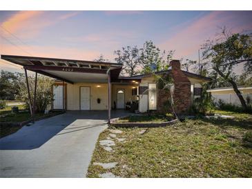 Charming single-story home featuring a carport, brick chimney and quaint front yard at 4002 W Gray St, Tampa, FL 33609