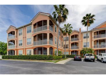 Multi-story condo building with screened patios, mature landscaping, and convenient parking spaces at 5000 Culbreath Key Way # 1-310, Tampa, FL 33611