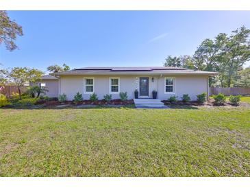 Charming one-story home featuring fresh landscaping, a bright facade and a well manicured green lawn at 4152 Gerry Ln, Land O Lakes, FL 34638