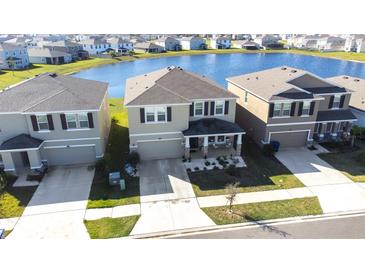A beautiful exterior view of the house with a lake nearby at 9119 Forge Breeze Loop, Wesley Chapel, FL 33545