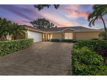 Charming single-story home with a brick driveway, lush landscaping, and a two-car garage at 1426 75Th Ne Cir, St Petersburg, FL 33702