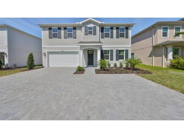 Charming two-story home features a large brick driveway, attached garage, manicured lawn, and classic black shutters at 3913 W Euclid Ave, Tampa, FL 33629