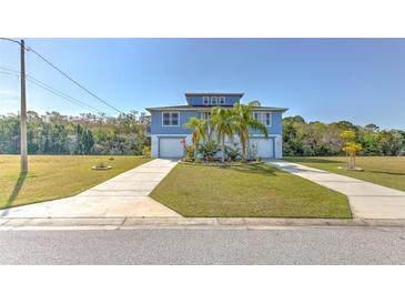 Charming two-story home with a well-manicured lawn and double driveways at 4010 Jewfish Dr, Hernando Beach, FL 34607
