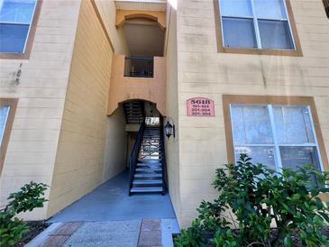 Exterior of a condo building with stairs leading to multiple units and well-maintained landscaping at 5618 Pinnacle Heights Cir # 104, Tampa, FL 33624