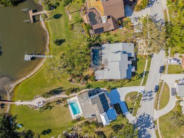 Stunning aerial view of waterfront homes featuring private docks, lush landscaping, and sparkling swimming pools at 9011 Baywood Park Dr, Seminole, FL 33777