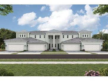 Beautiful townhome exterior featuring multiple garage bays, column accents, and lush green landscaping at 12785 Jade Empress Loop # 202, Venice, FL 34293