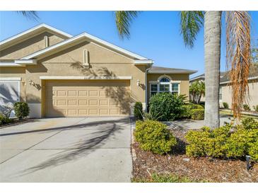 Inviting single-Gathering home featuring a two-car garage, manicured landscaping, and a well-maintained lawn at 2253 Oakley Green Dr # 26, Sun City Center, FL 33573
