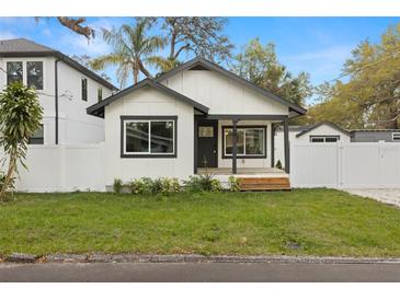 Charming home featuring a crisp black and white color scheme and a well-manicured front lawn at 1103 E Louisiana Ave, Tampa, FL 33603