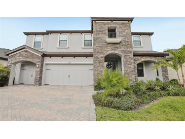 Stunning two-story home featuring stone accents, a two-car garage, and beautiful landscaping at 13176 Twin Bridges Dr, Riverview, FL 33579