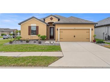 Charming single-Gathering home featuring a well-manicured lawn and a two-car garage at 313 Old Windsor Way, Spring Hill, FL 34609
