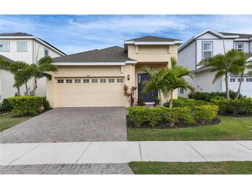 Charming single-Gathering home with manicured landscaping, paved driveway, and attached two-car garage at 407 Sandsend Ct, Apollo Beach, FL 33572