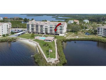 Waterfront condominium with a swimming pool, an American flag, and water views at 4650 Bay Blvd # 1012, Port Richey, FL 34668