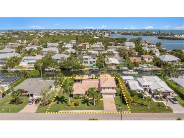 Aerial view of waterfront home with lush landscaping and a private dock with boating access at 520 74Th St, Holmes Beach, FL 34217
