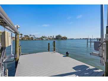 Waterfront dock with boat lift and open water views on a sunny day at 5451 Oakhurst Dr, Seminole, FL 33772