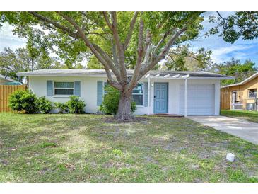 Charming single-story home with a blue door and well-maintained front yard landscaping at 280 Twin Lake Dr, Largo, FL 33770