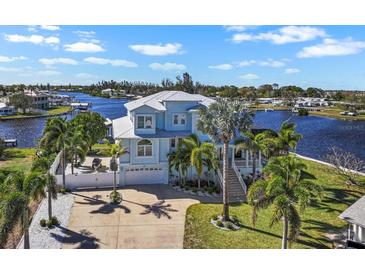Beautiful waterfront home featuring lush landscaping, white picket fence, and a private dock at 829 Blue Heron Blvd, Ruskin, FL 33570
