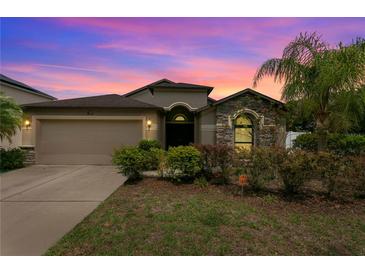 Charming single Gathering home featuring a stone facade, mature landscaping and a two car garage at 1426 Main St, Valrico, FL 33594
