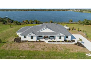 Aerial view of a beautiful home with a large yard, close to a serene lake at 3319 Gulf City Rd, Ruskin, FL 33570