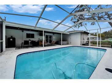 Inviting screened-in pool area with outdoor dining, barbecue and jacuzzi for enjoying a relaxing outdoor lifestyle at 4118 Ramona Dr, Spring Hill, FL 34606