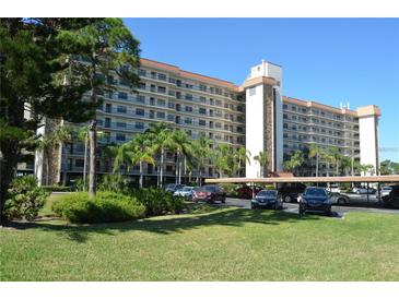 Multi-story condo building featuring balconies and parking with tropical landscaping in a sunny setting at 5400 Park N St # 200, St Petersburg, FL 33709