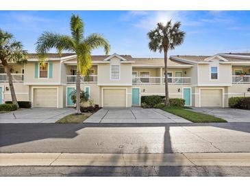 Townhome featuring a private garage, balcony and a beautiful exterior with manicured lawn and landscaping at 12308 Sun Vista W Ct # 45, Treasure Island, FL 33706