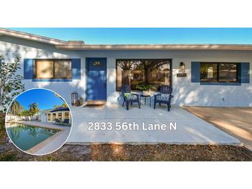 Charming single-story home featuring a blue door, shutters, and a well-maintained front yard with seating area at 2833 56Th N Ln, St Petersburg, FL 33710