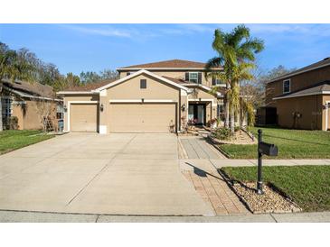 Charming two-story home with a spacious driveway and a well-manicured lawn and a three car garage at 5843 Justicia Loop, Land O Lakes, FL 34639