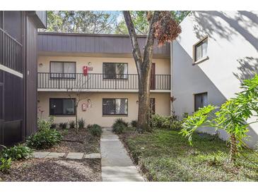 Two-story condo featuring exterior walkway access and well-maintained landscaping, providing a welcoming outdoor aesthetic at 11706 Raintree Village Blvd # D, Temple Terrace, FL 33617