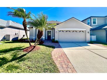Charming home exterior featuring a two-car garage and lush landscaping at 1945 Fruitridge St, Brandon, FL 33510
