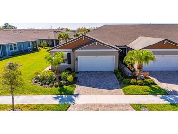 Charming single-story home with a well-manicured lawn, lush landscaping, and a two-car garage at 3753 Maxwell Park Dr, Sun City Center, FL 33573
