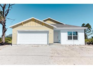 Charming one-story home features a two-car garage and a sunny yellow exterior at 434 Albatross Rd, Rotonda West, FL 33947